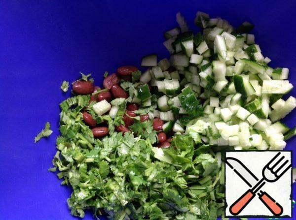 In a salad bowl, put the boiled beans,
chop the coriander. Cucumbers cut into small cubes.