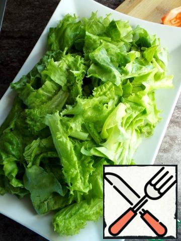 Pick the lettuce leaves with your hands and immediately put them on a plate.