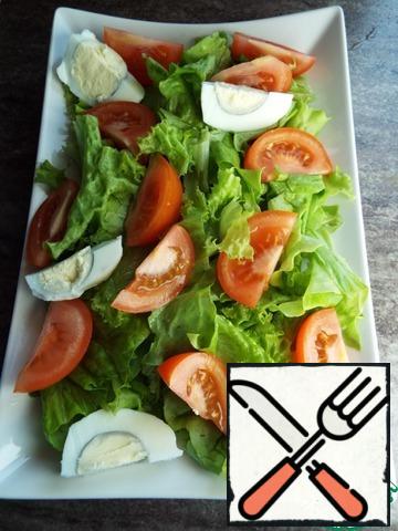 Put the tomatoes and the egg, cut into four pieces, on the lettuce leaves.