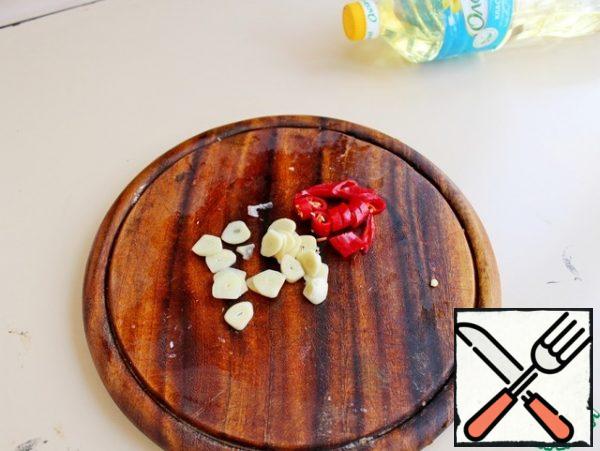 Chilli pepper and garlic cut into thin rings and add to the vegetables, fry for 1 min.