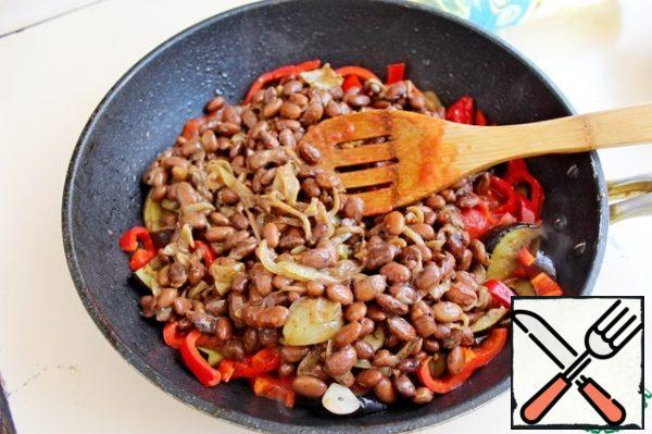 Add separately fried onions and mixed with red canned beans, cook for 2 minutes.