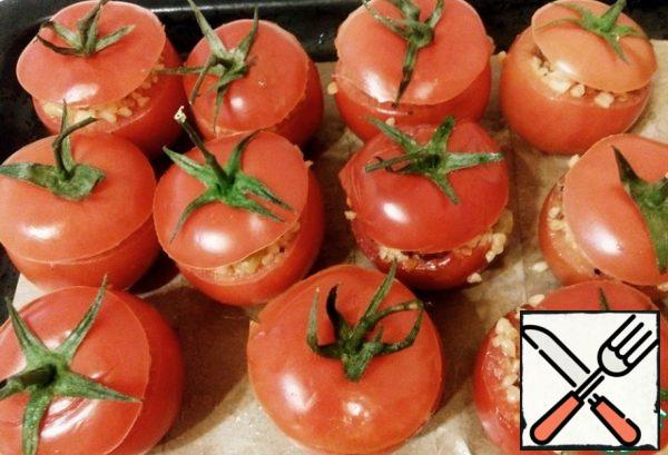 We stuff the tomatoes with two fillings, close the lids. Grease the baking sheet with vegetable oil, I also put the paper, also lubricate with oil. Put in the preheated oven to 200 degrees for 20-30 minutes.