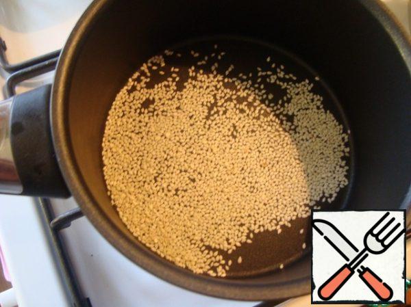 Sesame seeds are fried in a dry pan.