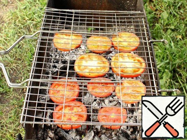 Tomatoes wash, dry and cut into circles. Put on the grill and fry on the grill until tender.
Baked vegetables, after removing from the grill, immediately cut into random pieces and put in a cup.