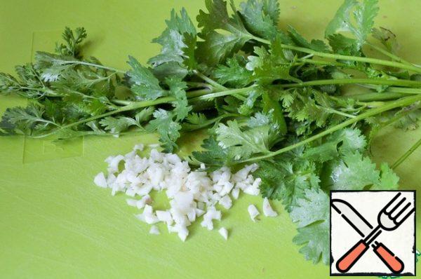 Peel the garlic and chop it finely. Slice the coriander. Add everything to the vegetables.