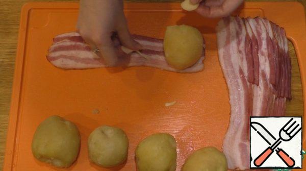 Before you wrap the potatoes in bacon, it should be well salted, and put the slices of garlic on the slices of bacon.