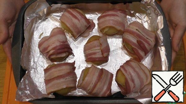 Put the potatoes wrapped in bacon in an oven preheated to 200 degrees for 15-20 minutes.