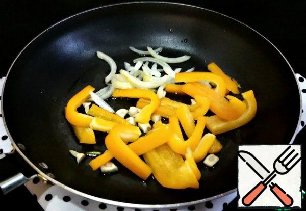 Cut the onion into half rings, add to the garlic and lightly fry. Add the bell pepper, cut into strips, and heat for two minutes.