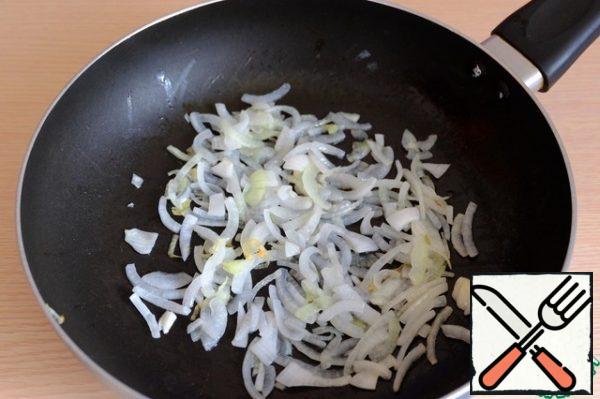 Add vegetable oil (1 tablespoon) to the pan, add half-rings of onion. Simmer the onion over low heat until soft and transparent