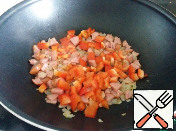 We cut the pepper into cubes and also send it to the pan,