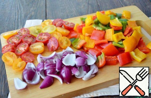 Medium peppers of three colors cut coarsely, cherry tomatoes into halves, onions cut into four parts, separate it.