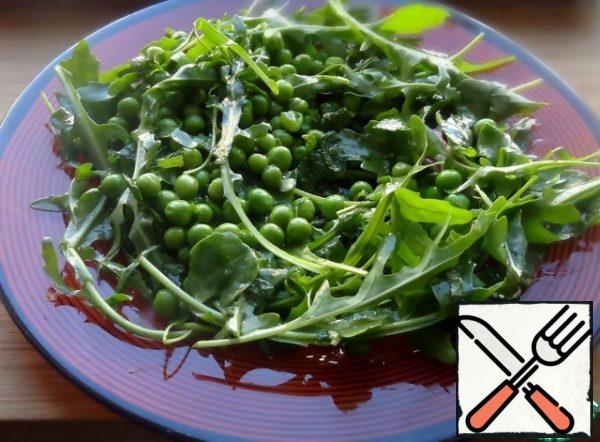 Mix the arugula and peas with the dressing and place on a plate.