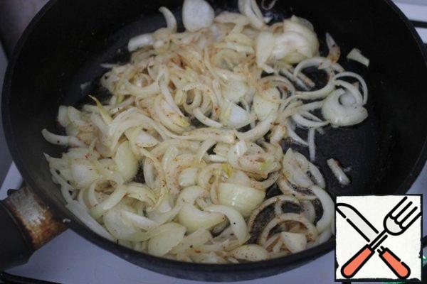Cut the onion into half rings and fry in a frying pan, greased with vegetable oil until soft and transparent.