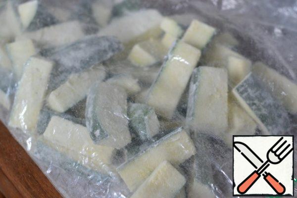 Tie the bag and gently, taking the corners, shake, so that the zucchini pieces roll in flour.