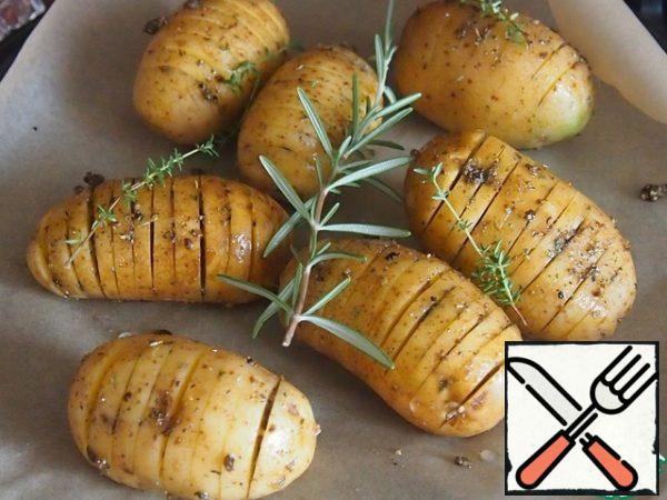 Cover a baking tray or baking dish with baking paper, spread out the potatoes, and grease with the remaining sauce. If there is fresh rosemary and thyme, spread the sprigs on the potatoes.