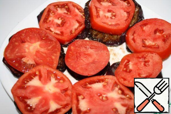 We put the eggplants on a plate or immediately on pieces with bread.
Cut the tomato into pucks and put it on a circle of eggplant.
