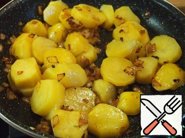 In a frying pan, pour the onion and fry until soft. Add the butter and fry the onion until golden brown.
Cut the potatoes into slices 1 cm thick or slightly larger and add them to the onion. Gently stir with a spatula and fry a little, just 1 minute.