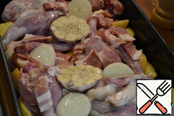 Cut the bacon into medium-sized pieces. Add to the form.
Onion and garlic head (do not peel) cut in half.
Add to the rabbit.
Add wine and water.
Cover with foil and bake in a preheated oven at 180g for 45 minutes.