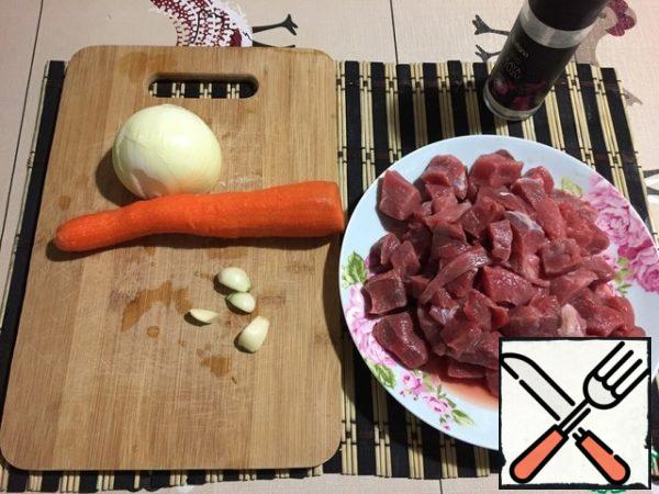 We will prepare all the products. Wash and slice the meat. Peel the carrots, onions, and garlic.