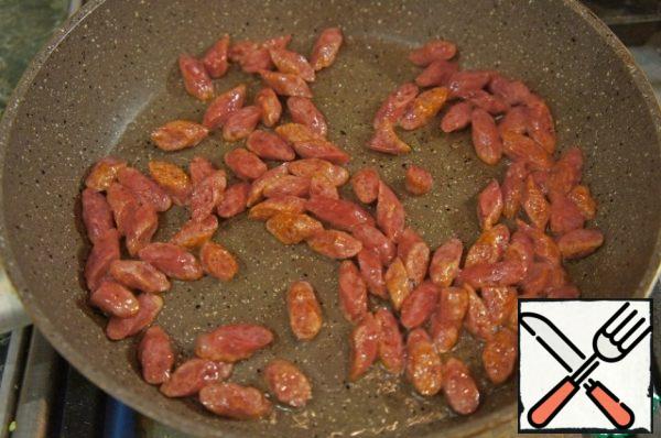 Fry the hunting sausages in a frying pan in olive oil until golden brown.