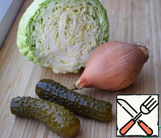 Chop the cabbage. Peel and chop the onion. Slice the pickles.