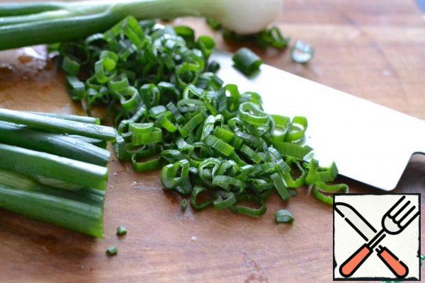 Finely chop the green onion. Fry it in sunflower oil.