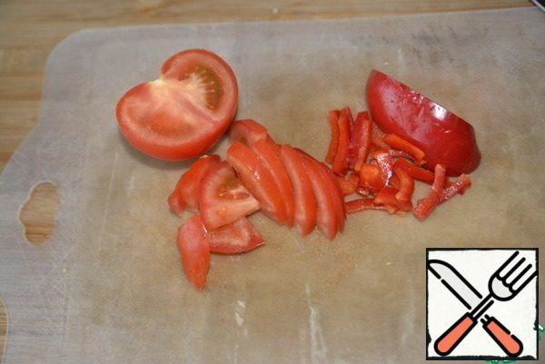Cut tomatoes and bell peppers into small pieces (strips or segments).