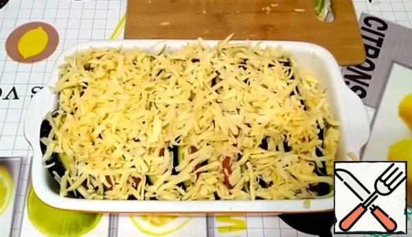 Sprinkle with grated cheese on top.
We send it to the preheated oven to 180 degrees for about 25-30 minutes.
The cooking time may vary. Check the readiness of the zucchini with a knife - they should be soft.