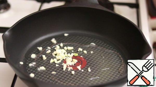 In a preheated frying pan with the addition of vegetable oil, fry the garlic.