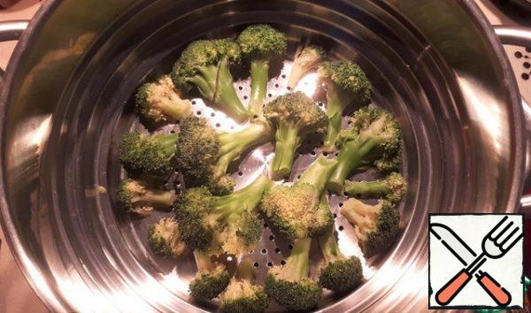 We disassemble the broccoli into inflorescences, put it in a steamer, sprinkle with salt and cook for a couple of 15 minutes.