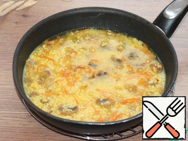 Add 300 ml of water, seasoning, salt and ground black pepper to the pan, mix. Reduce the heat to low, cover the pan with a lid and cook for 15-20 minutes or until the bulgur is fully cooked.