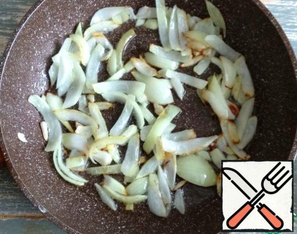 After half an hour after the beans are put to cook, peel the onion, cut at random, fry in olive oil until golden brown.