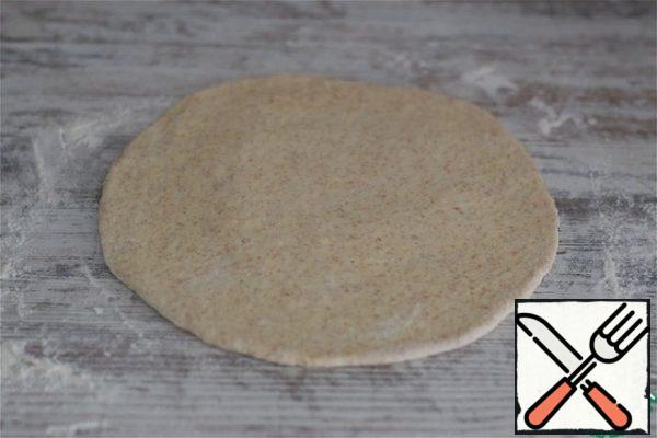 Place the dough on a work surface lightly dusted with flour, knead, and divide into four equal parts. You can make one large pie, two medium-sized pies, or several small ones. Molding - at your request! I cook 4 round pies like Ossetian ones.
Roll out each part of the dough into a circle 3-4 mm thick.