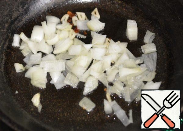 Onion cut into cubes, put in a frying pan. Fry until transparent.