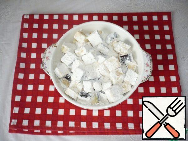 Roll the eggplant cubes in cornstarch. For convenience, put them in a bowl, pour the starch and mix.