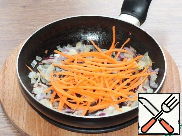 In garlic oil, fry the peeled and chopped vegetables: onion cubes and carrot strips.