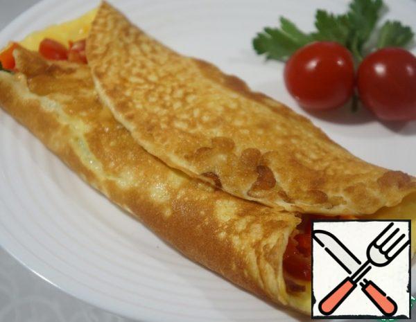 5. As soon as the omelet thickens, put the cubes of ham, pepper, tomato on it, sprinkle with grated cheese on top.
6. Roll the omelet into a roll, cover and cook for another 1-2 minutes, until the cheese melts.
7. Serve the finished roll in a warm form.