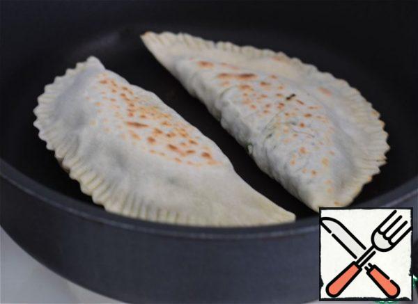 .. turn over, cover the pan with a lid and cook the kutabs for another two to three minutes.
The pan after each fried batch should be wiped with a paper towel, thereby removing the flour that has fallen off the dough.