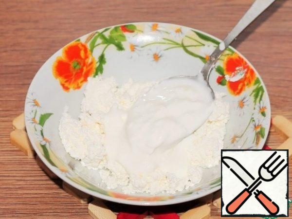 Add sour cream to the mashed cottage cheese and mix.