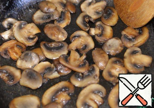 In a hot deep frying pan, pour half the amount of vegetable oil and fry the mushrooms over high heat until browned. Remove the mushrooms from the pan.