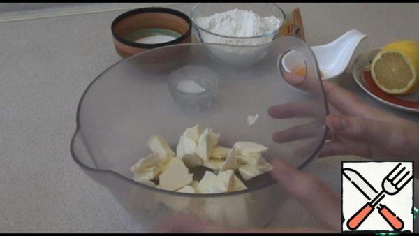 Butter from the refrigerator cut into pieces, add sugar, vanilla sugar, egg yolk, lemon juice, most of the flour, baking powder and knead the dough.