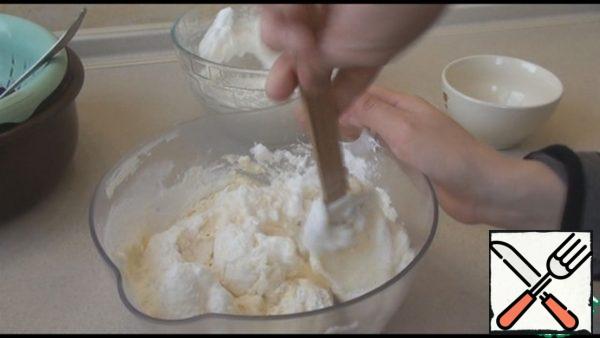 Add a little whipped whites to the curd mass and stir well with a spatula from the bottom up. Here we also add corn starch.