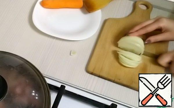 Meanwhile, cut the onion into half rings.