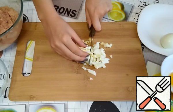 Prepare the filling for the minced chicken.
You need to finely chop 2 boiled eggs.
