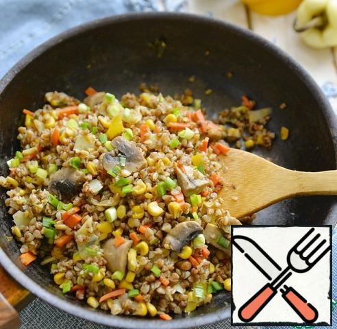 When ready, mix the buckwheat with vegetables, serve the dish hot, sprinkled with green onions.