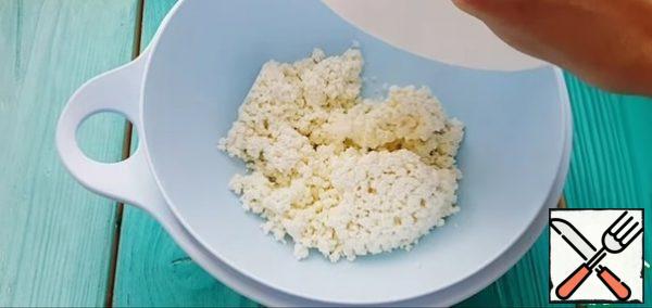 In the cottage cheese, add a pinch of salt, softened butter cut into cubes and knead with a fork until smooth.
Next, add the sifted flour in 2 stages, mix everything with a fork, and then knead the dough with your hands. It should be tight and not stick to your hands. It is advisable to put the flour gradually, since everyone has a different flour, it may take a little more flour or less)