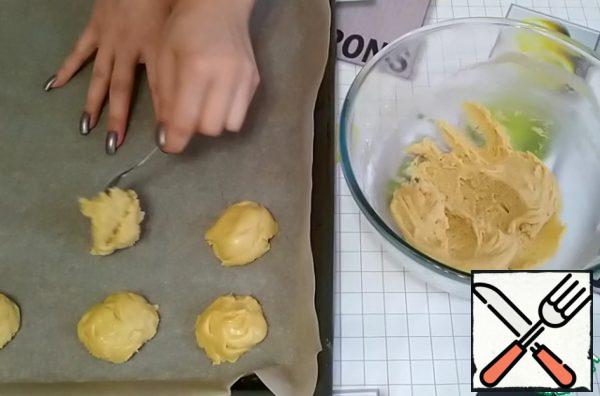 Knead the dough well.
On a baking sheet lined with parchment paper, we form cookies with a teaspoon.
I got 14 pieces.