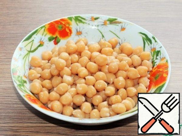 Pre-prepared chickpeas are boiled according to the instructions. The broth from the cooked chickpeas is drained into a bowl and removed to the side.