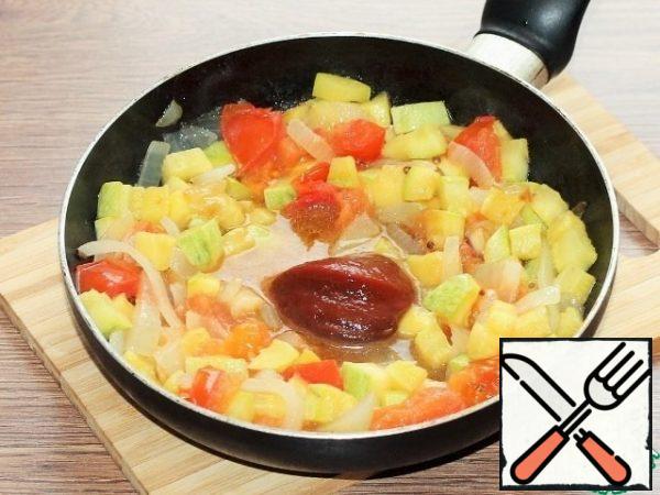 We push the vegetables to the edge of the pan, and put the tomato paste in the middle, fry it in vegetable oil for 1-2 minutes. Then mix the pasta with the vegetables.