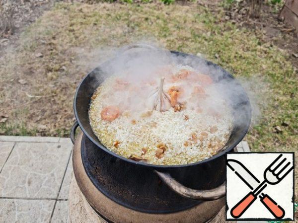 The pilaf is ready. Put the garlic head in the center.
